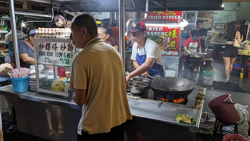 Peniaga char kuey teow memasak di gerai makan