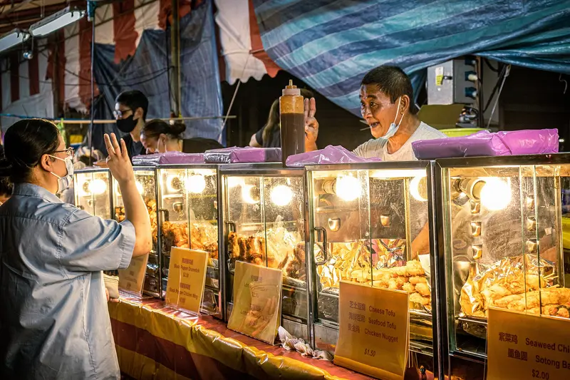 Peniaga pasar malam melayan pelanggan